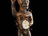 un gros plan sur la statue d'une personne tenant une horloge