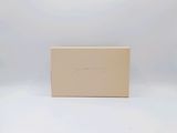 an empty box sitting on top of a white table next to a white wall
