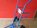 a blue hand truck that is sitting on the floor