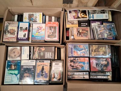 un grand nombre de dvd dans une boîte posée sur le sol