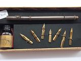 a box with a pen, ink bottle, and other items in it
