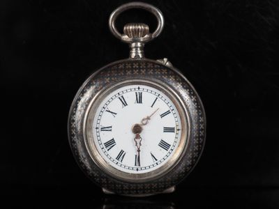 une montre de poche en argent avec des chiffres romains sur le cadran