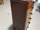 a dresser in the middle of a room with a ladder in the background