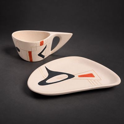 une assiette blanche ornée d'un motif noir et orange