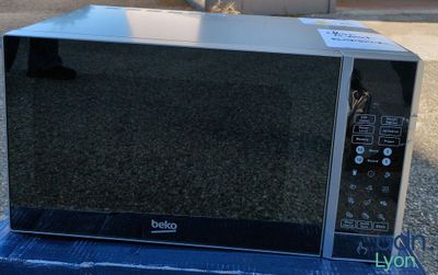 un micro-ondes posé sur une boîte dans la rue