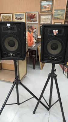 une paire d'enceintes posées sur un trépied dans une pièce