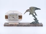 a statue of a bird and a clock on a stand