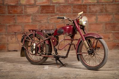 a red motorcycle that is parked in front of a brick wall