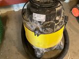 a yellow and black vacuum sitting on the floor next to other items