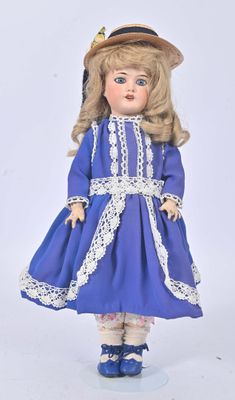 a doll that is wearing a blue dress and hat