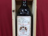 une bouteille de vin rouge dans un coffret en bois sur fond rouge