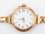 une image d'un gros plan d'une montre-bracelet sur une surface blanche