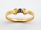 gros plan d'une bague en or avec une pierre en saphir