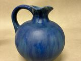 a blue vase sitting on a table with a white background