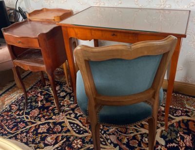 une table en verre avec une chaise bleue et un bureau en bois