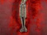 a statue of a man holding a cross on a red cloth