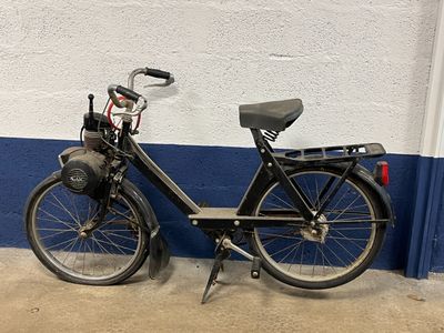a black bicycle parked against a white and blue wall