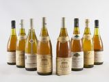 six bottles of wine lined up in a row on a white surface