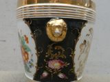 un vase noir et doré orné d'une tête de lion