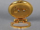 an image of a gold clock with blue eyes on a stand