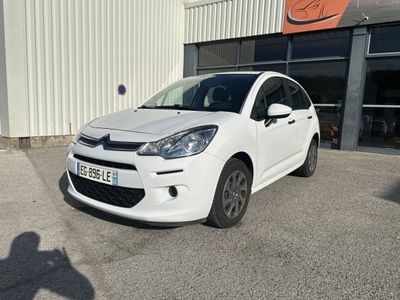 la petite voiture blanche est garée devant un bâtiment