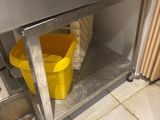 a yellow bucket sitting under a sink in a kitchen