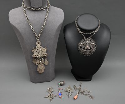 deux colliers et un collier posé sur un présentoir pour mannequin