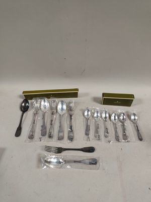 beaucoup de couverts sur une table, à côté d'une boîte d'allumettes