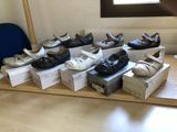 many pairs of shoes that are sitting on a table