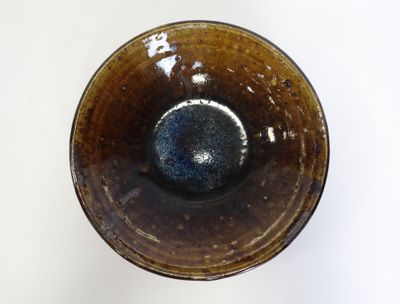 a brown and blue bowl on a white surface