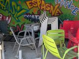 de nombreuses chaises et tables dans une pièce dont les murs sont couverts de graffitis