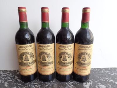four bottles of wine are lined up on a table