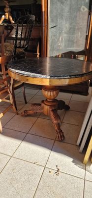 une table avec un plateau en marbre et des chaises dans une pièce