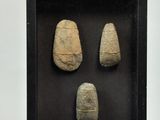 three pieces of stone in a shadow box on display