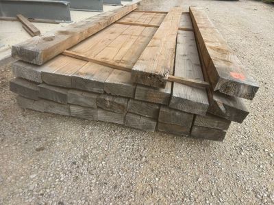 plusieurs morceaux de bois sont empilés sur un parking