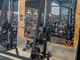 an image of a gym room with a barbell rack and weights