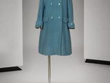 une photo d'un manteau bleu sur un présentoir pour mannequin