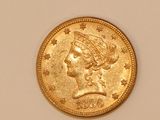 a close up of a gold coin with a woman ' s head on it