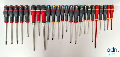 many different types of screwdrivers lined up on a wall