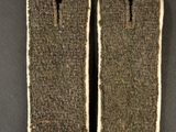 pair of army uniform tags with red buttons on a gray background