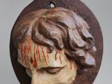 a wooden ornament with a face of jesus on it