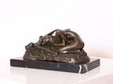 statue représentant une femme allongée sur un rocher, posée sur un socle en marbre
