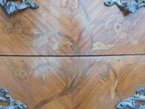a close up of a wooden chest of drawers with ornate handles