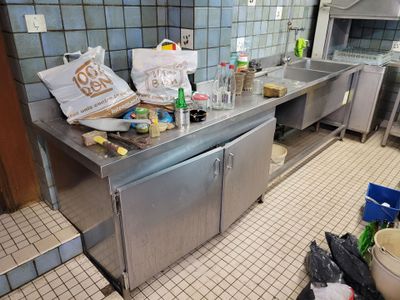 une cuisine avec beaucoup de désordre sur le comptoir
