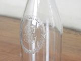 a clear glass bottle with a flower design on it