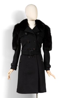 un manteau noir à col de fourrure sur un mannequin