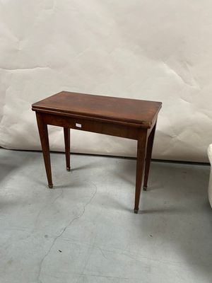 two small tables and a chair in a room with a white wall