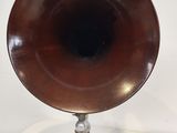 a small wooden speaker on a stand on a white surface