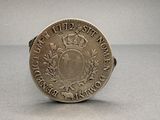 an old coin with a crown on top of it sitting on a table