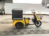 a yellow motorcycle with a black box on the back of it